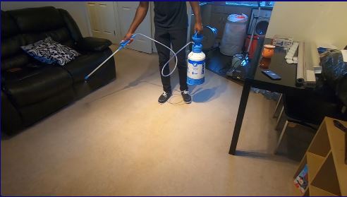 Carpet cleaning technician pre-spraying carpet
